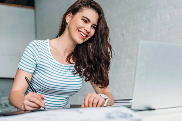 Selective focus of happy animator looking at laptop — Stock Photo