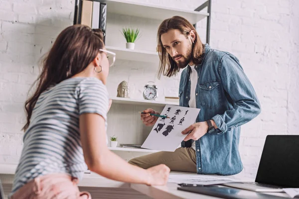 Enfoque selectivo de ilustrador barbudo mirando a la mujer y la celebración de dibujos animados - foto de stock