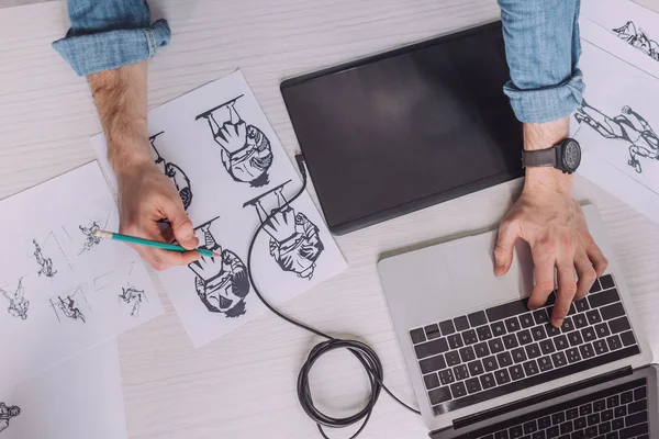 Top view of illustrator drawing cartoon sketches on paper — Stock Photo
