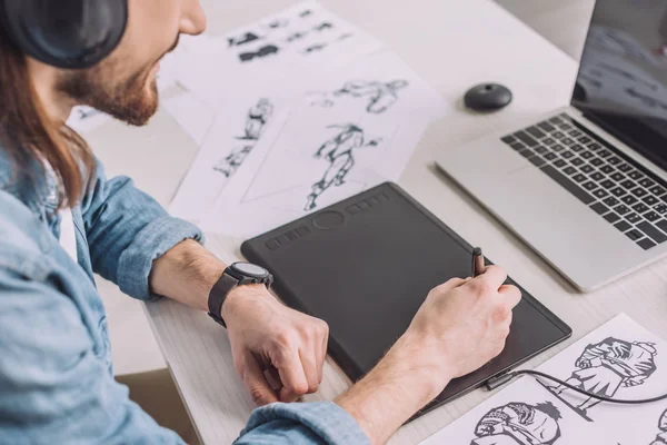 Cropped view of animator in headphones using digital tablet — Stock Photo