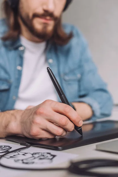 Mise au point sélective de l'animateur à l'aide d'une tablette numérique près du papier avec croquis — Photo de stock