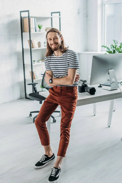 Cheerful bearded editor with crossed arms smiling in studio — Stock Photo