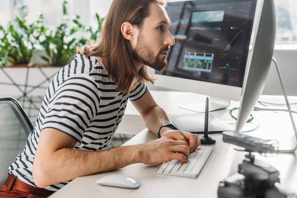 Side view of bearded art editor working in studio — Stock Photo
