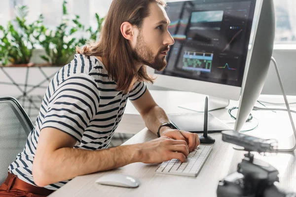 Seitenansicht eines bärtigen Redakteurs, der im Atelier arbeitet — Stockfoto