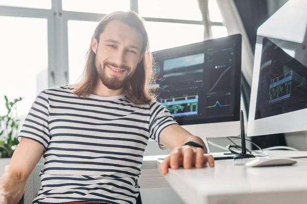 Selective focus of happy bearded editor looking at camera — Stock Photo