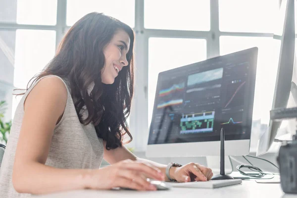 Foyer sélectif de femme heureuse travaillant dans le studio près du moniteur d'ordinateur — Photo de stock