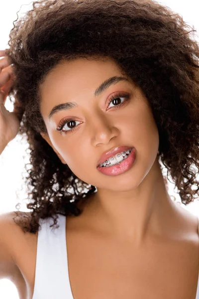 Chica afroamericana sonriente con frenos dentales mirando a la cámara, aislado en blanco - foto de stock