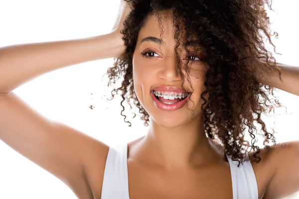 Позитивна брюнетка афроамериканська дівчина з зубними брекетами, ізольована на білому — стокове фото