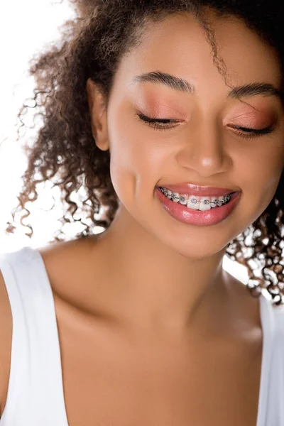 Bela menina americana africana sorridente com aparelho dentário, isolado em branco — Fotografia de Stock