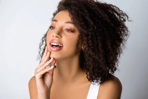 Cheerful african american girl with dental braces, isolated on grey — Stock Photo