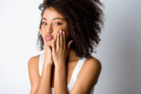 Retrato de hermosa chica afroamericana feliz haciendo mueca divertida, aislado en gris - foto de stock