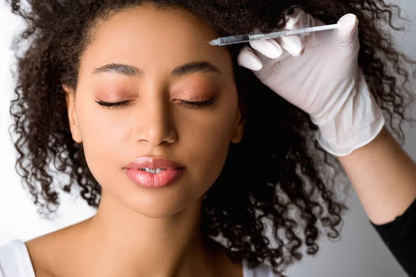 Attractive african american woman making beauty injection, isolated on grey — Stock Photo