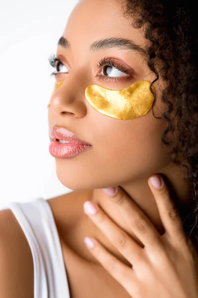 Привлекательная африканская американка с золотыми повязками на глазу, изолированная на сером — стоковое фото