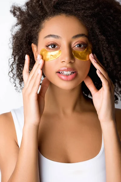 Chica americana africana rizada con parches de ojos dorados, aislada en gris - foto de stock