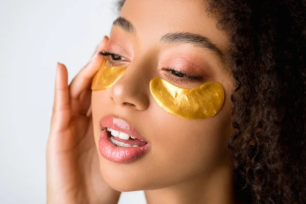 Menina americana africana atraente com manchas olho dourado, isolado em cinza — Fotografia de Stock