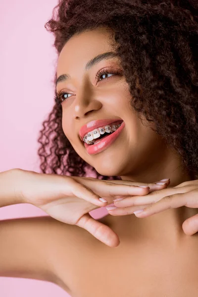 Eccitata ragazza afroamericana con bretelle dentali, isolata su rosa — Foto stock