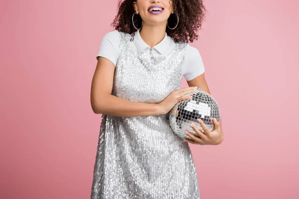 Menina americana africana feliz em paillettes vestido segurando bola de discoteca, isolado em rosa — Fotografia de Stock