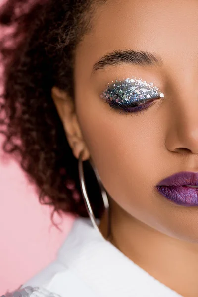 Belle fille afro-américaine aux fards à paupières à paillettes argentées et aux lèvres violettes, isolée sur rose — Photo de stock