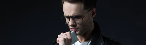 Homme élégant et stressé veste en cuir avec smartphone isolé sur noir, vue panoramique — Photo de stock