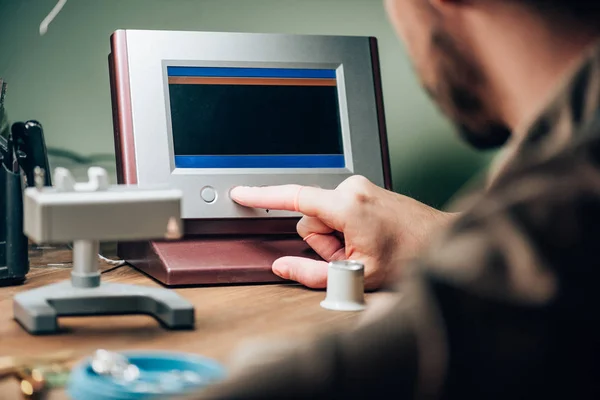 Selective focus of clockmaker working with watch tester at table — Stock Photo