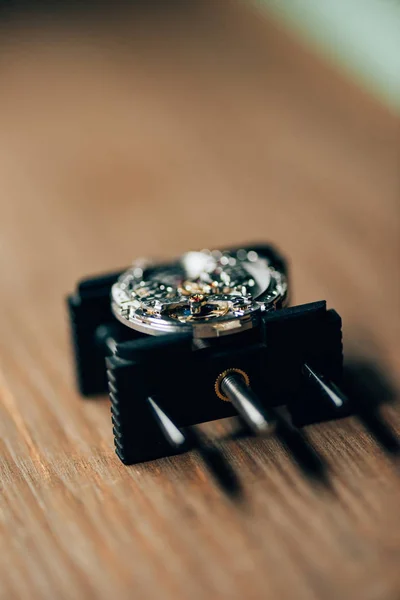 Focus selettivo dell'orologio da polso aperto sul supporto di movimento sul tavolo — Foto stock