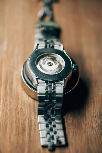 Close up view of wristwatch on stand on wooden table — Stock Photo