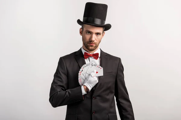 Magician holding playing cards, isolated on grey — Stock Photo