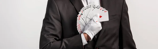 Cropped view of magician holding playing cards, isolated on grey, panoramic shot — Stock Photo