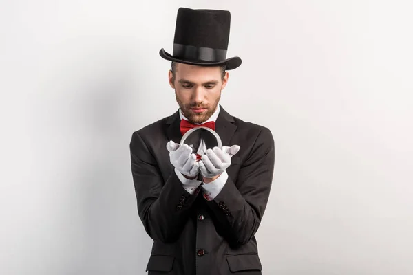 Professional magician looking at magic ball, isolated on grey — Stock Photo