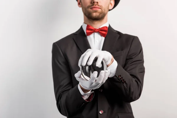 Vista recortada de mago profesional sosteniendo bola mágica, aislado en gris - foto de stock
