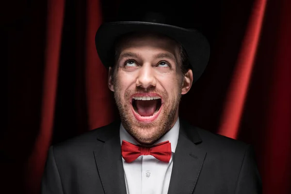 Effrayant excité gentleman avec bouche ouverte dans le cirque avec des rideaux rouges — Photo de stock