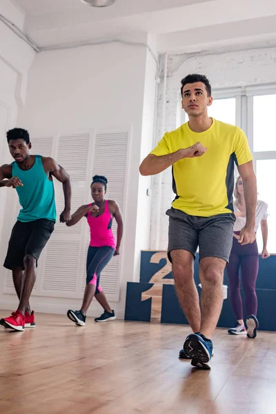 Low angle view of multicultural dancers practicing zumba in dance studio — Stock Photo