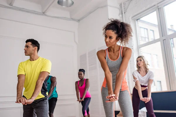 Foco seletivo de movimentos de treinamento de dançarinos de zumba multiétnicos em estúdio de dança — Fotografia de Stock