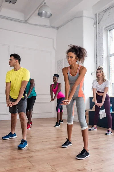 Giovani ballerini multietnici che eseguono zumba in studio di danza — Foto stock