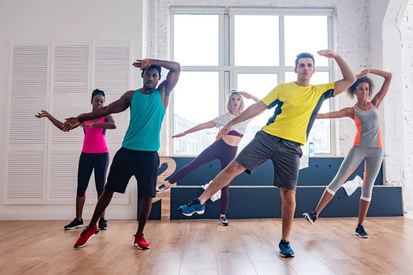 Багатокультурні танцюристи виконують зумбу в танцювальній студії — стокове фото