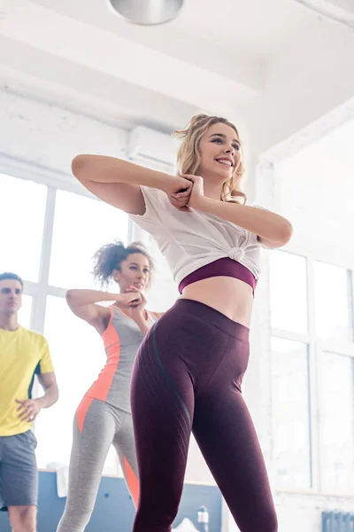 Low angle view of young multiethnic dancers training zumba movements in dance studio — Stock Photo