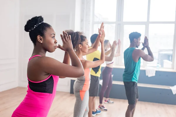 Foco seletivo de dançarinos de zumba multicultural praticando com treinador afro-americano no estúdio de dança — Fotografia de Stock