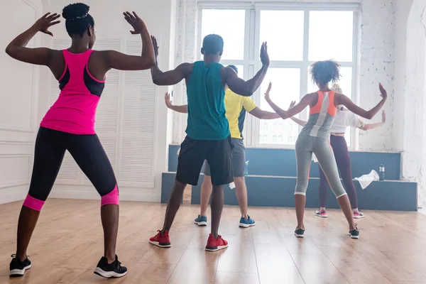 Rückseite von multikulturellen Tänzern, die Zumba im Tanzstudio aufführen — Stockfoto