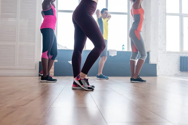 Side view of multicultural dancers exercising zumba choreography in dance studio — Stock Photo