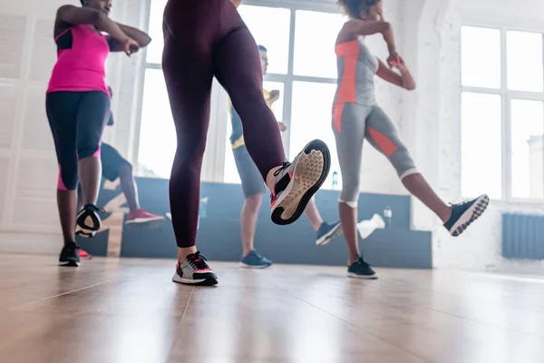 Vista de baixo ângulo de dançarinos multiculturais praticando zumba no estúdio de dança — Fotografia de Stock