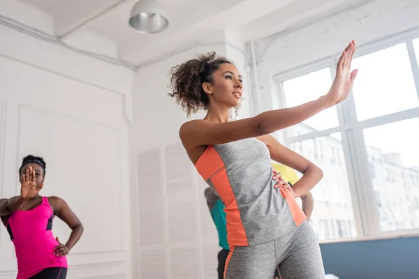 Vista de bajo ángulo de bailarines afroamericanos practicando zumba en estudio de danza - foto de stock