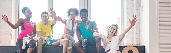 Fotografia panorâmica de dançarinos de zumba multicultural acenando com as mãos na câmera no estúdio de dança — Fotografia de Stock