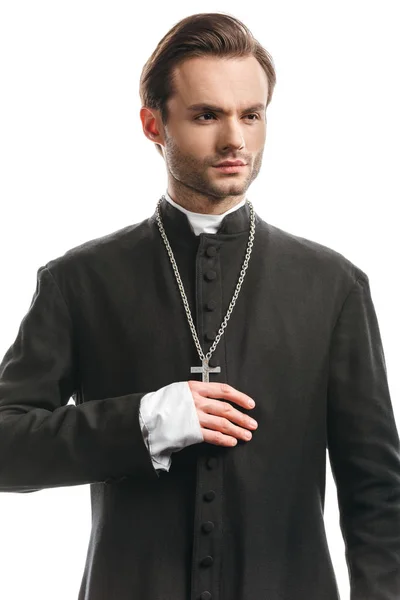 Молодой, уверенный в себе католический священник в черной рясе, смотрящий в сторону, изолированный на белом — стоковое фото