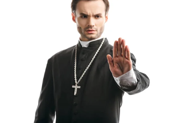 Selective focus of serious, strict catholic priest showing stop gesture isolated on white — Stock Photo