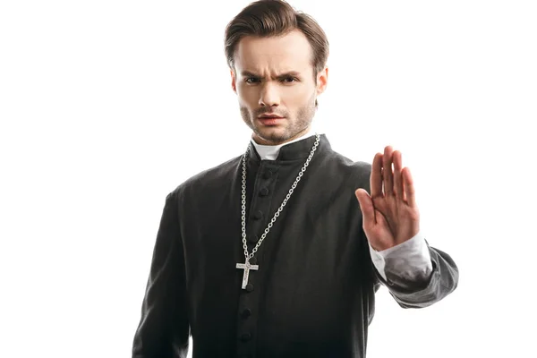 Серьезный, строгий католический священник, показывающий стоп-жест на камеру, изолированную на белом — стоковое фото