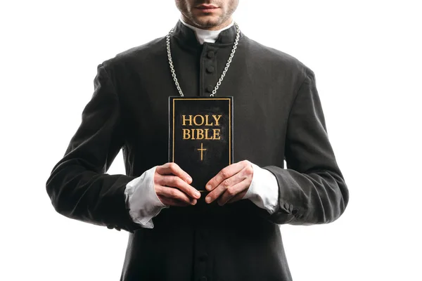 Vue recadrée du prêtre catholique tenant la bible sainte isolée sur blanc — Photo de stock