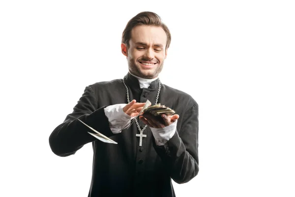 Sacerdote católico corrupto sonriendo mientras cuenta el dinero aislado en blanco - foto de stock