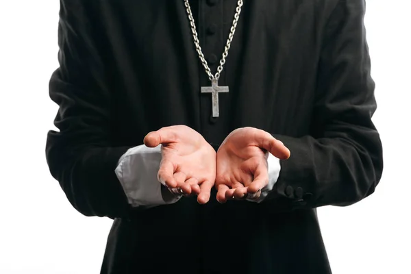 Cropped view of catholic priest with silver cross on neck standing with cupped hands isolated on white — Stock Photo