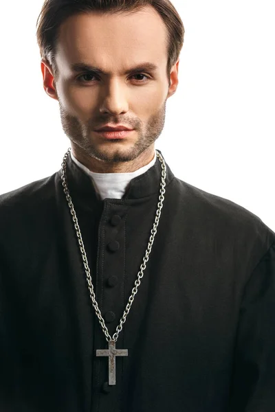 Young, concentrated catholic priest with silver cross on necklace looking at camera isolated on white — Stock Photo