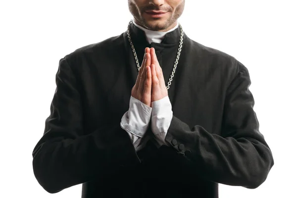 Обрезанный вид католического священника в черной рясе, молящегося изолированно на белом — стоковое фото